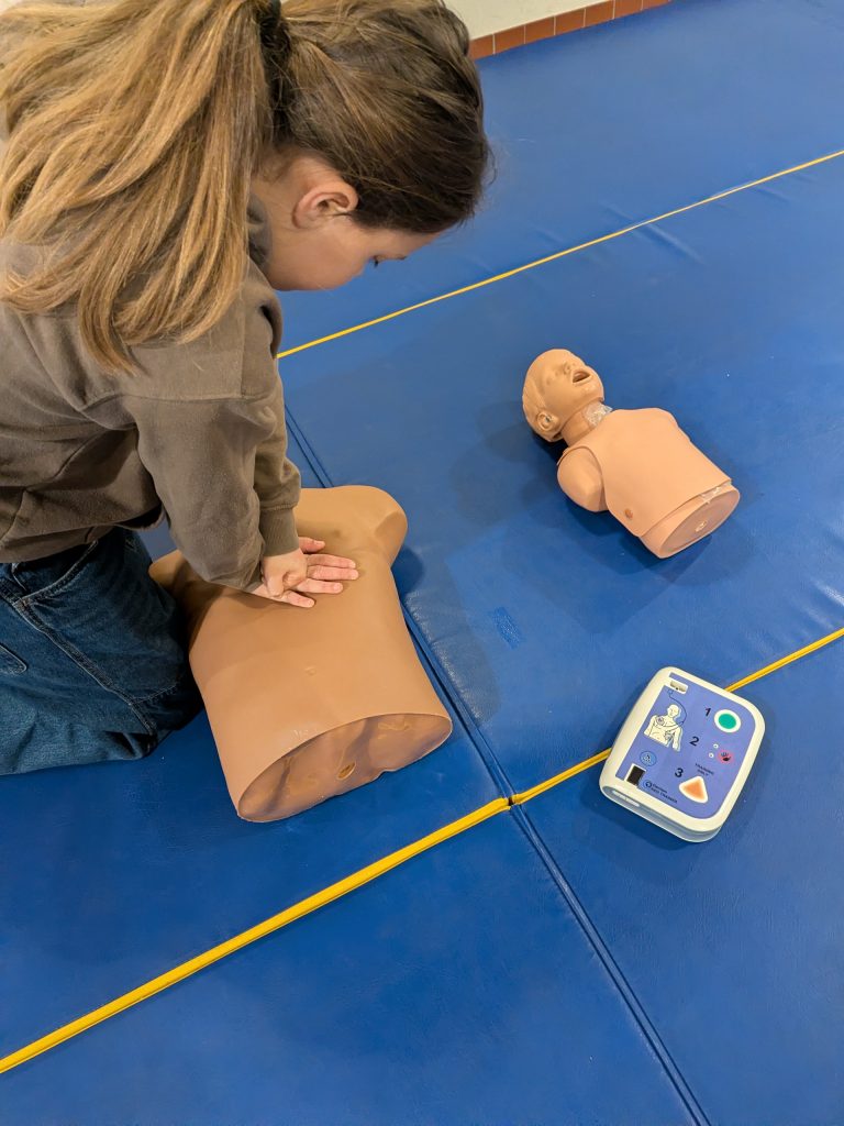 Exercice de compressions thoraciques sur mannequin avec un défibrillateur de formation
